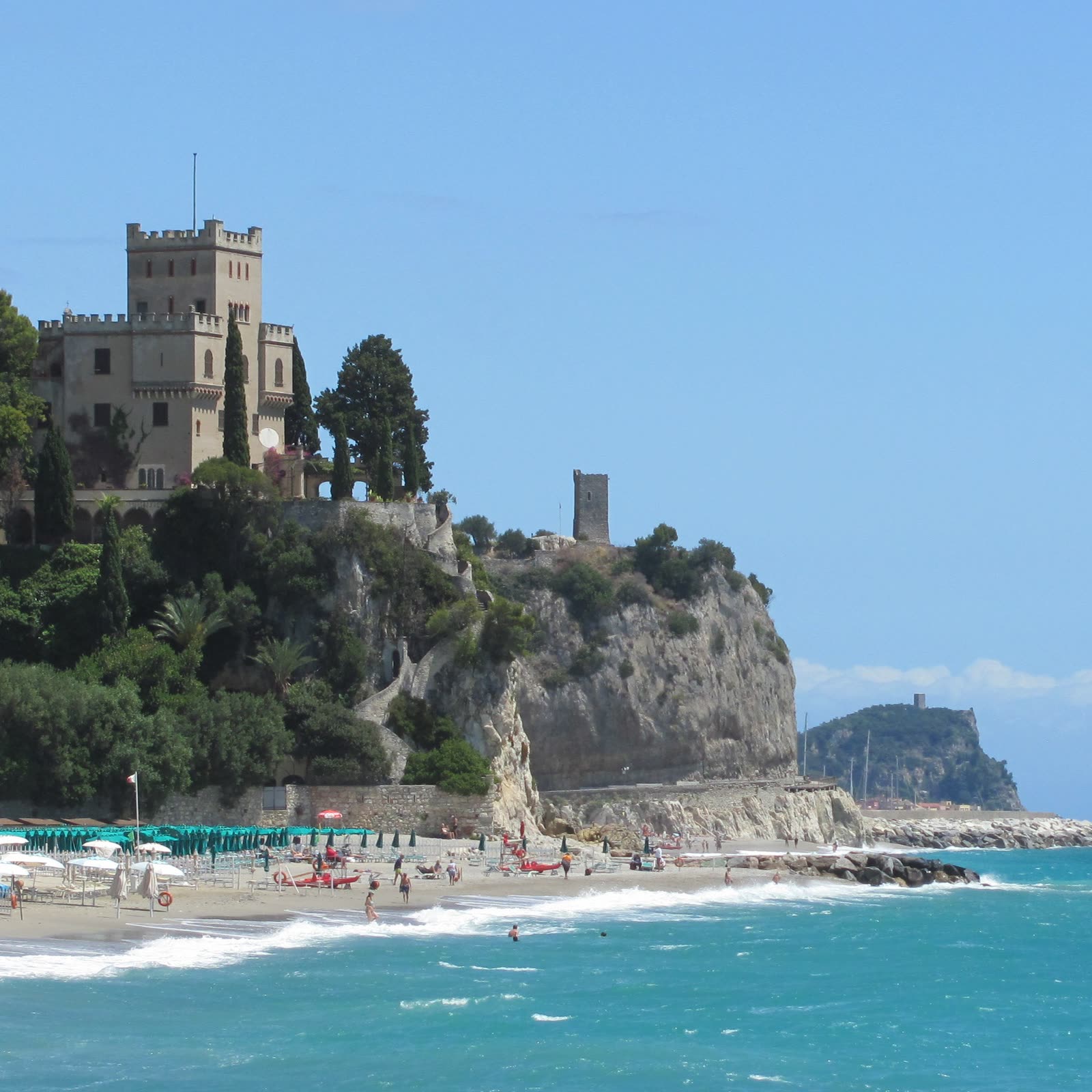 Stone castle on a headland above a Mediterranean beach