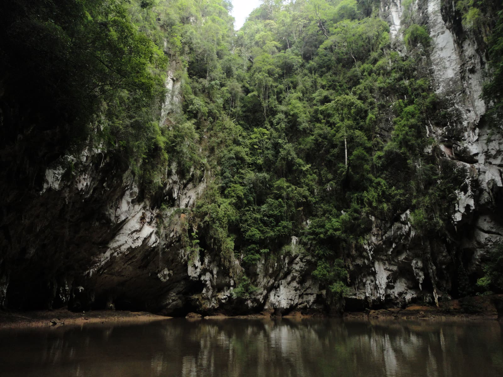 Overhanging limestone wall dropping straight into still water